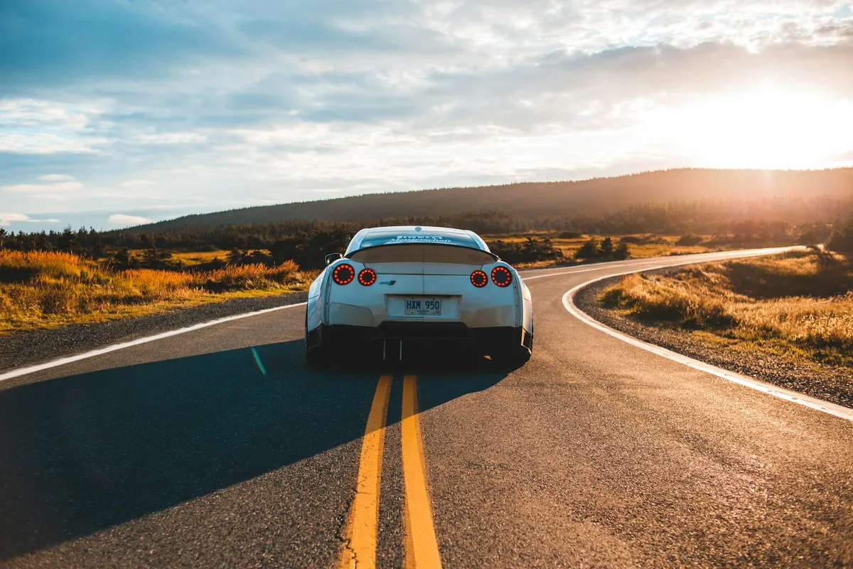 A rental car on an open highway at sunset