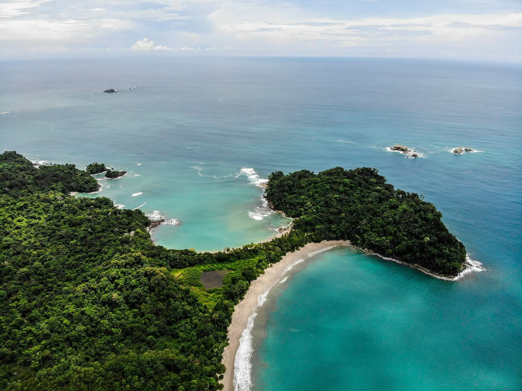 Aerial view of the forested point and twin coves of Manuel Antonio National Park on Costa Rica's Pacific coast
