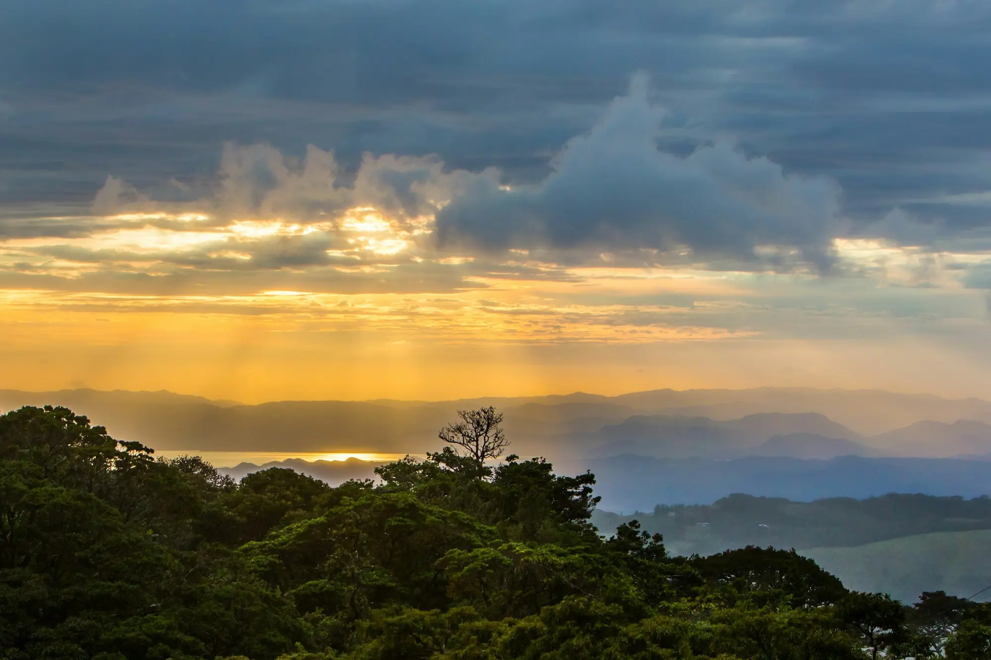 Mist and sun over the forested mountain ridges of the Monteverde cloud forest in Costa Rica