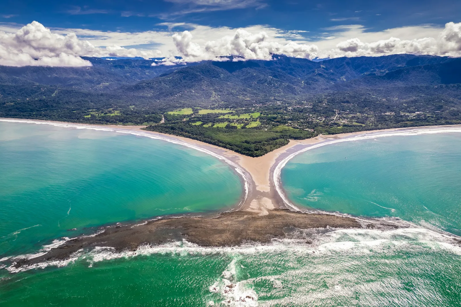 Aerial view of the Whale Tail sandbar at Marino Ballena National Park in Uvita, Costa Rica, with the coastline and mountains behind