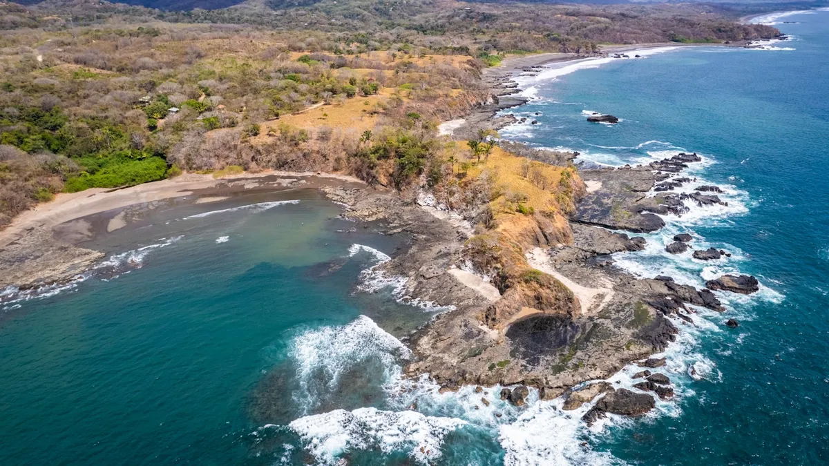 Rocky headland and dry-forest coastline of the Guanacaste Gold Coast near Playas del Coco, Costa Rica